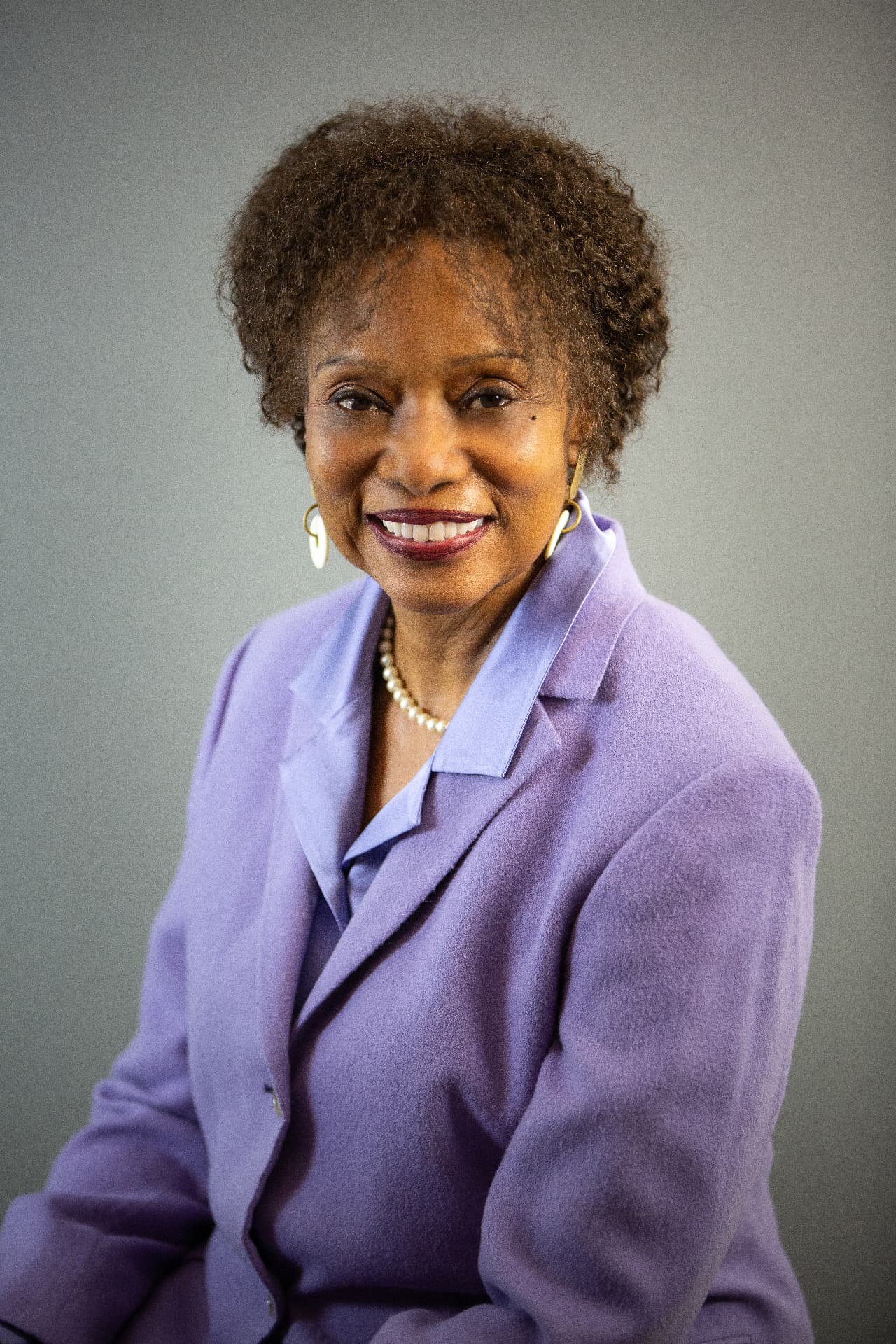 Executive headshot in a lavender jacket