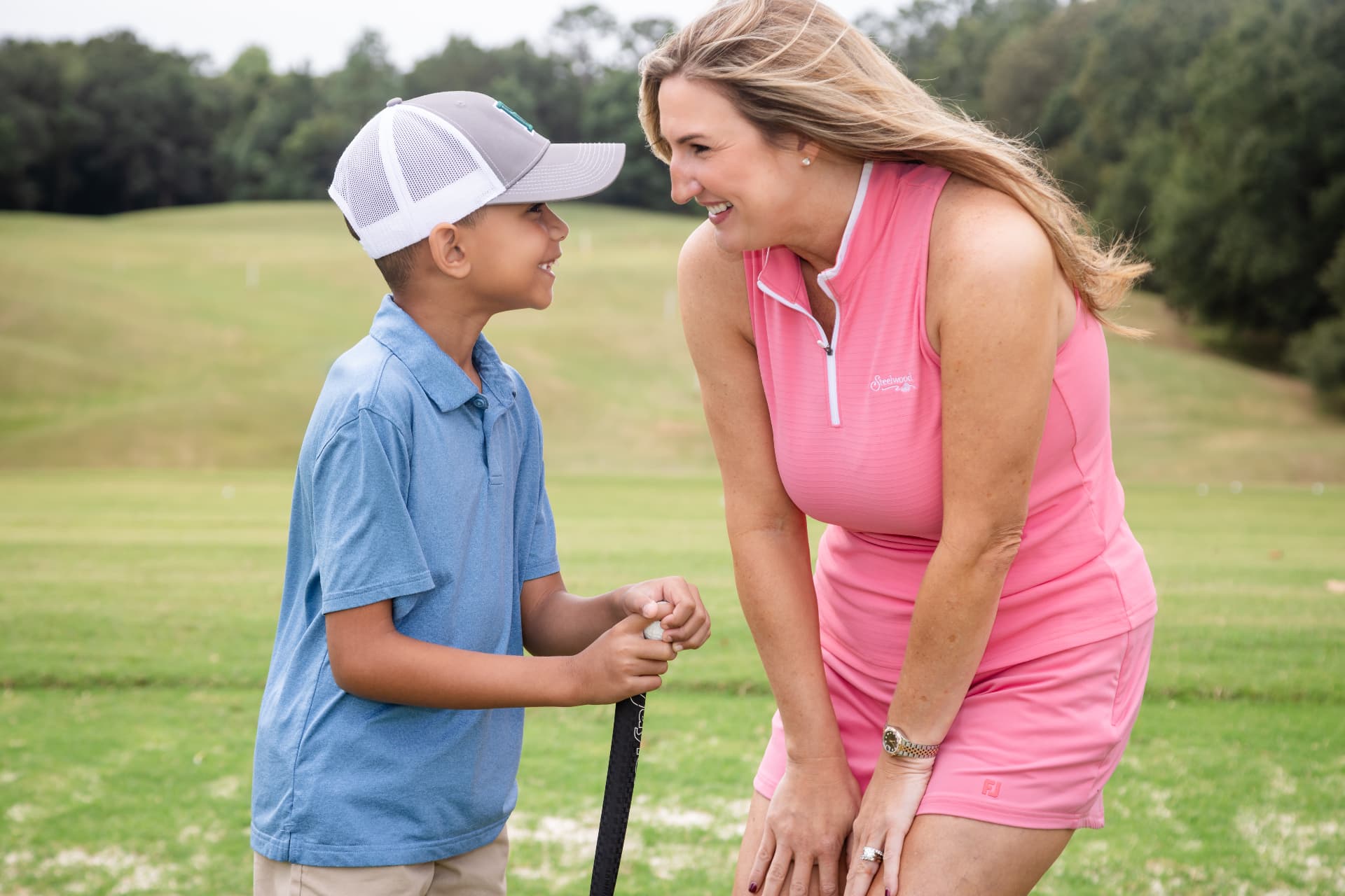 Mother and son laughing together on the golf course