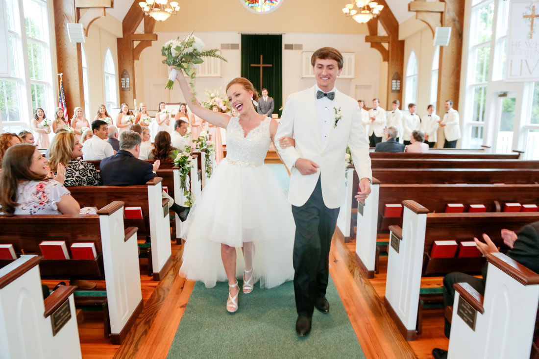 Bride and groom celebrating their exit down the chapel aisle