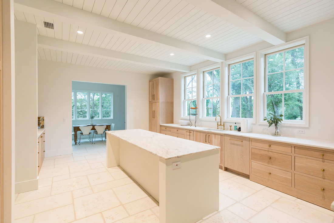 Kitchen with white oak cabinetry, marble island and tall windows
