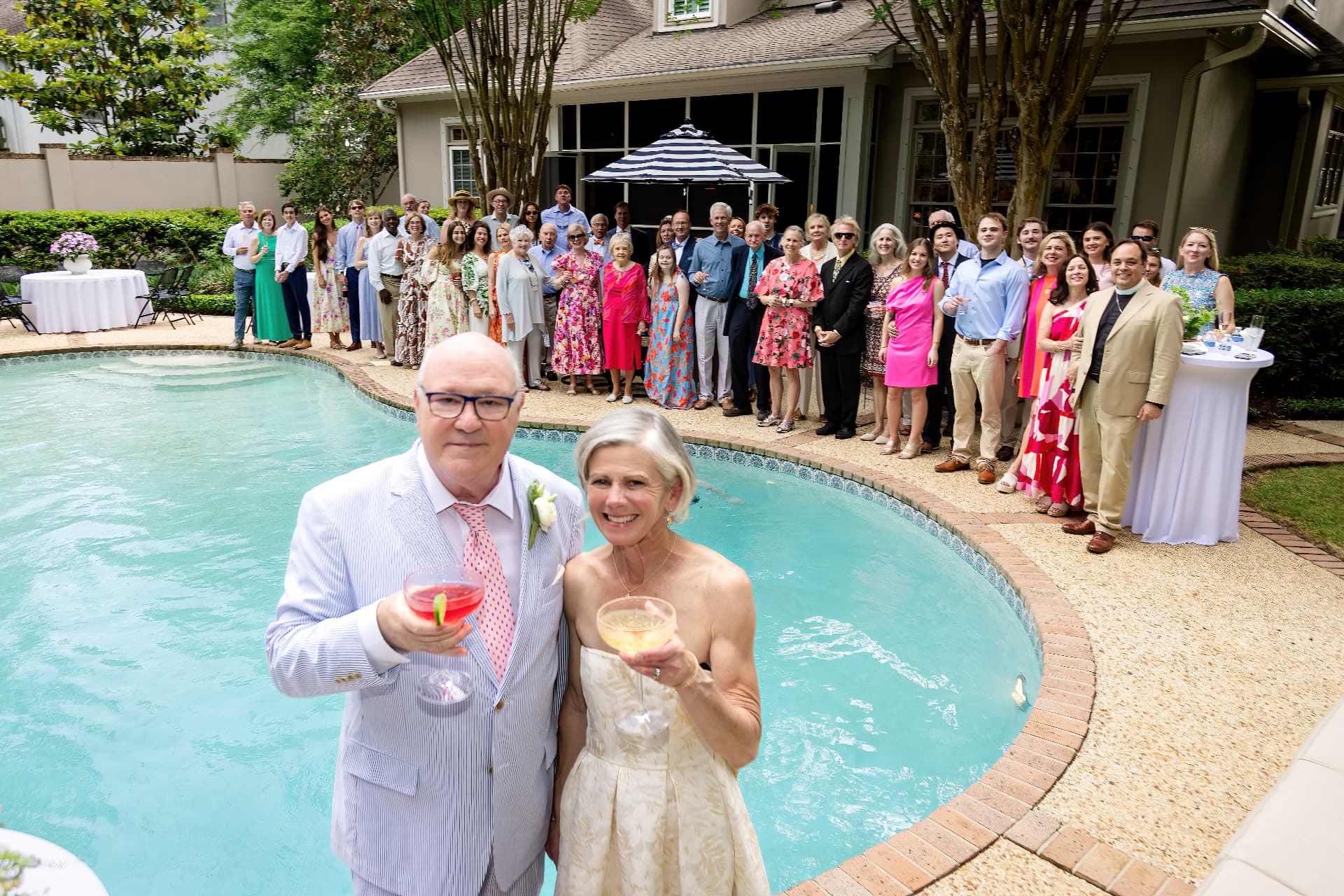 Wedding guests toasting by the pool at a colorful outdoor reception