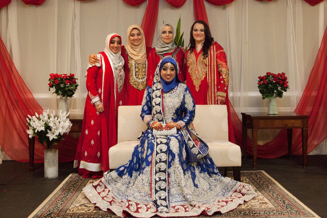 Bride seated with her party in red and blue formalwear