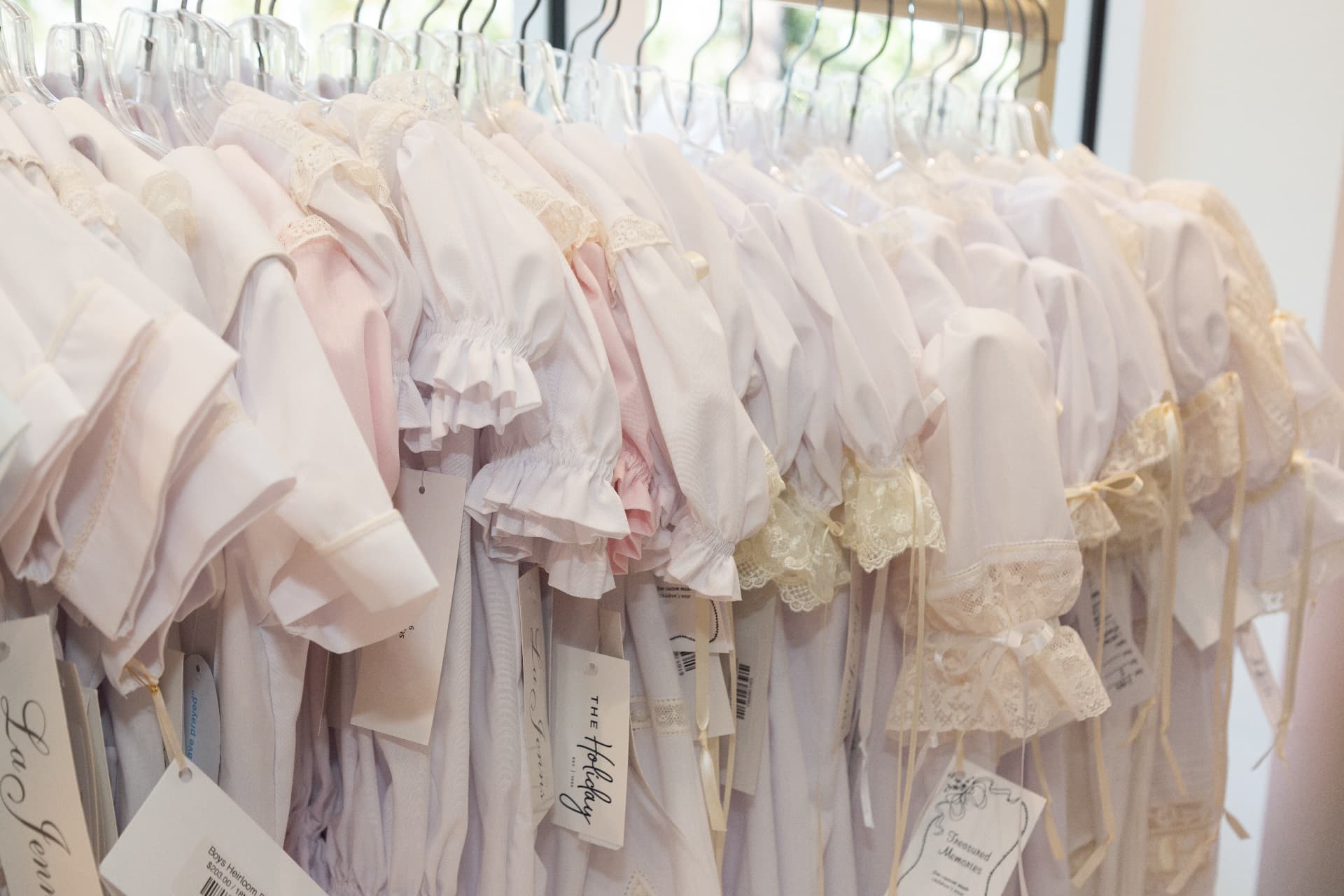 Rack of heirloom christening gowns at The Holiday boutique