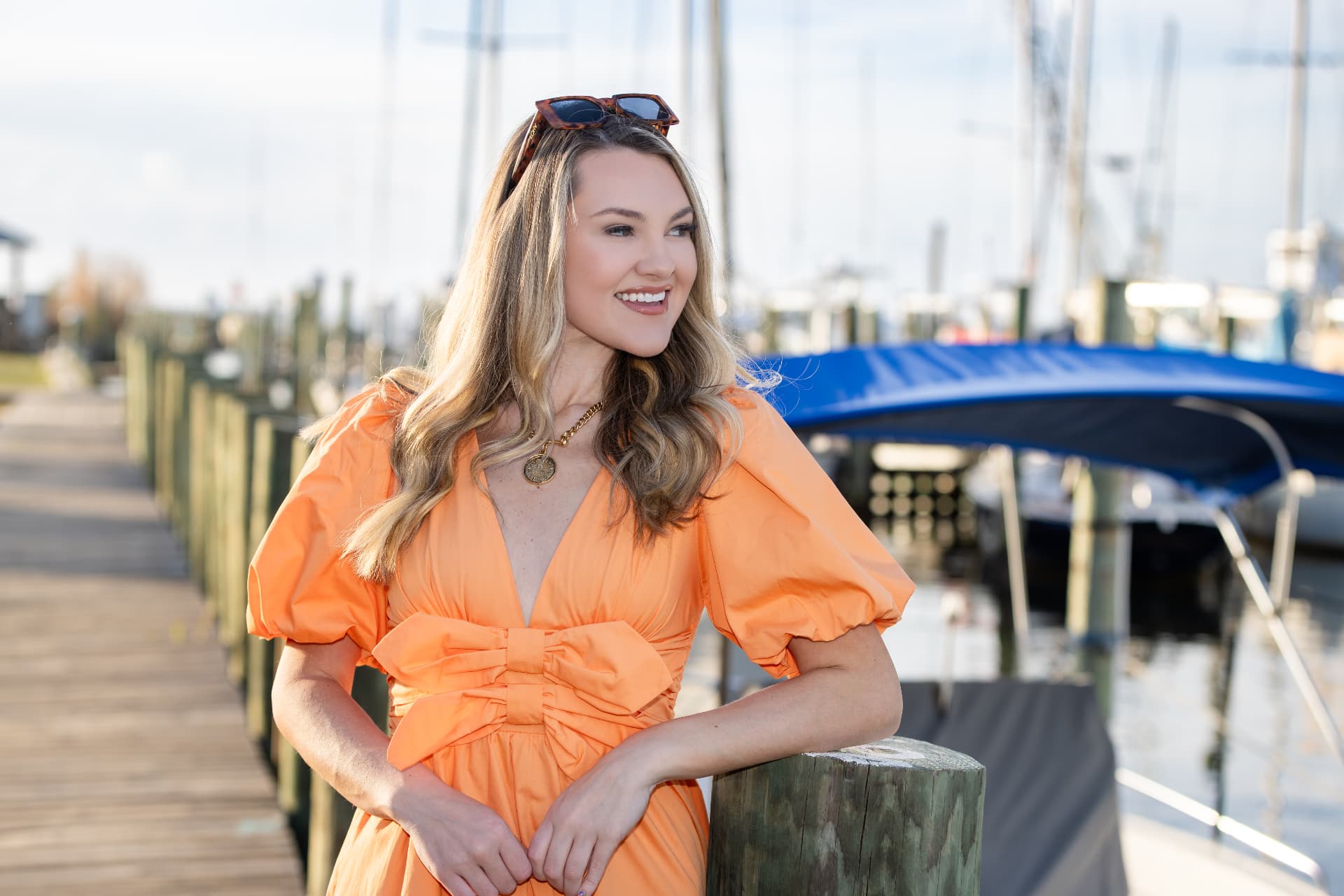 Model in an orange bow dress on the pier at Fairhope Yacht Club