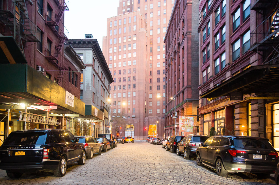 Cobblestone street lined with historic commercial buildings in New York City