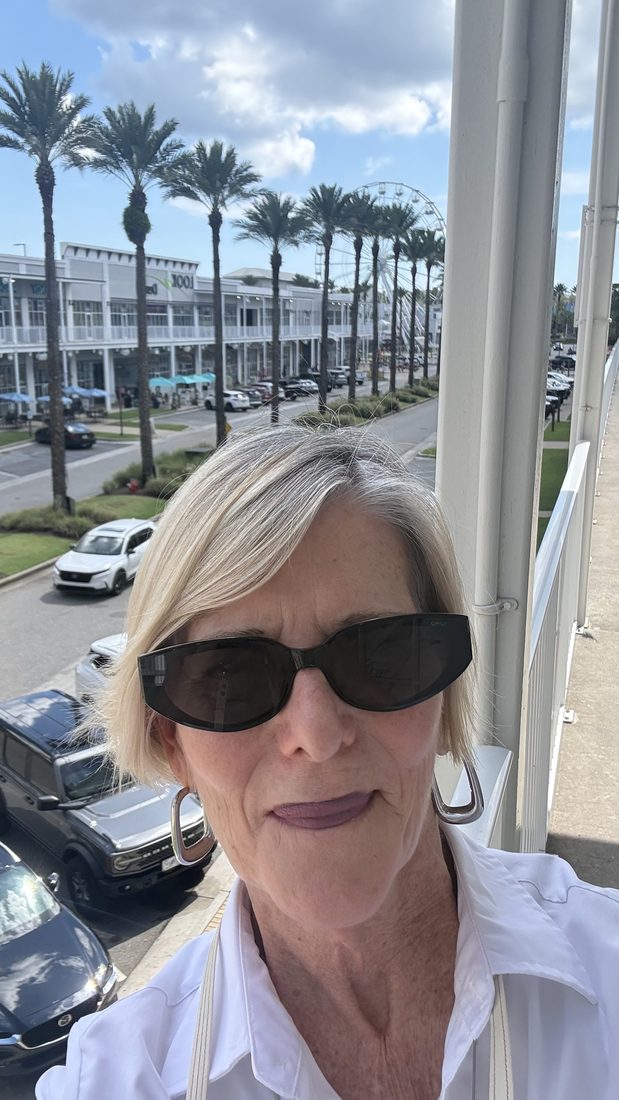 Cindy in sunglasses under the palm trees