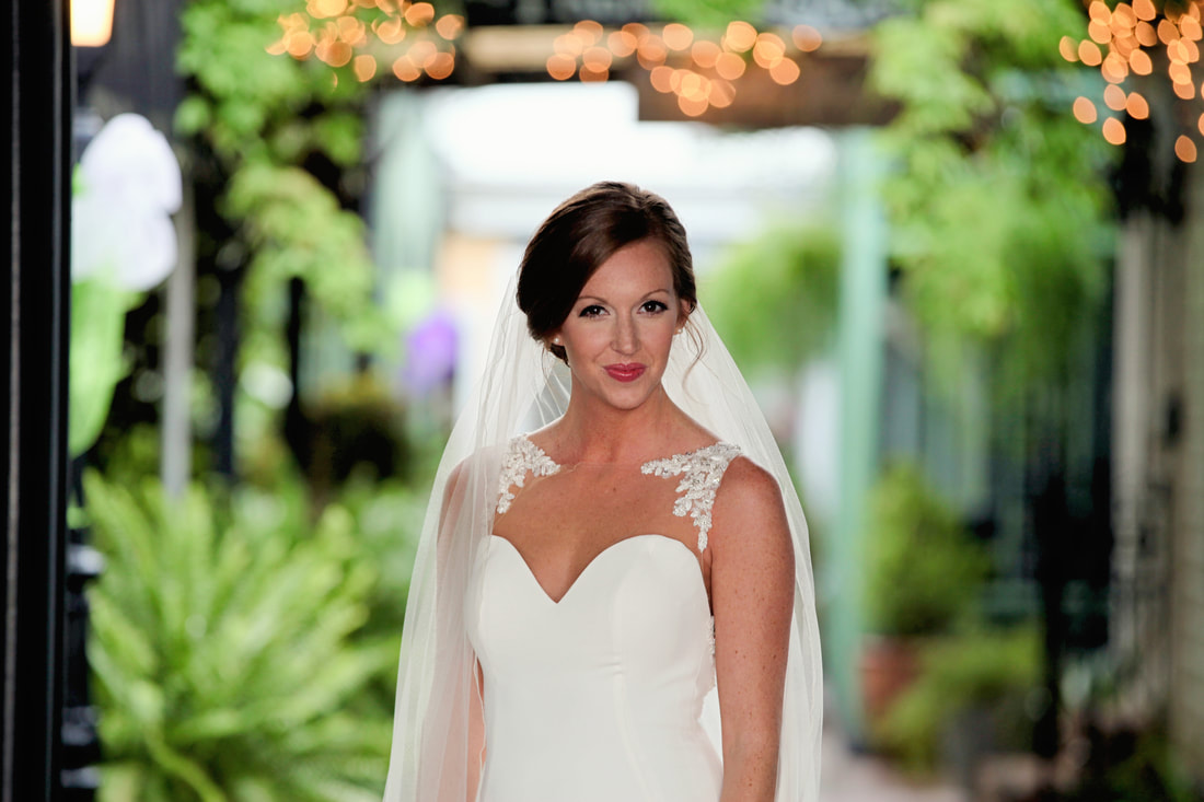Bride in her veil under courtyard string lights