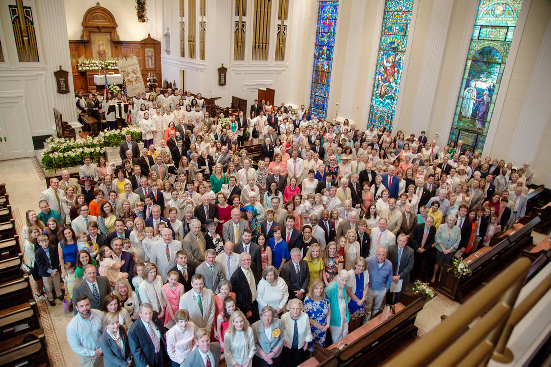 Full congregation group photograph in the nave beneath stained glass windows