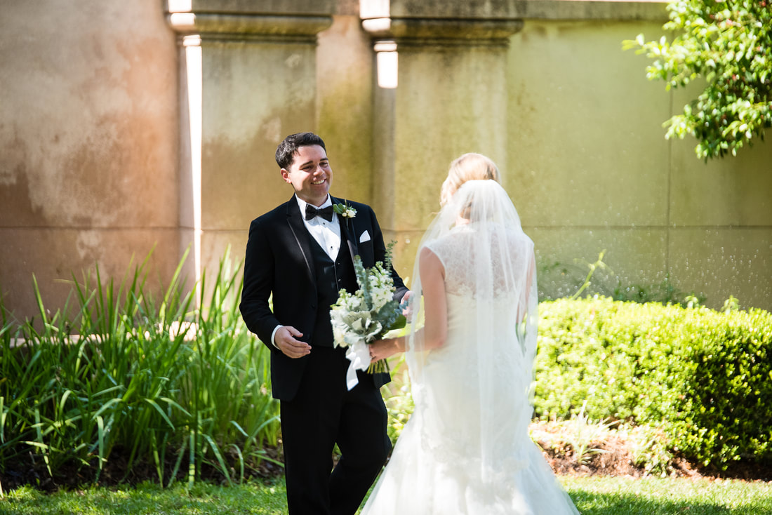 Groom's first look with the bride in a garden