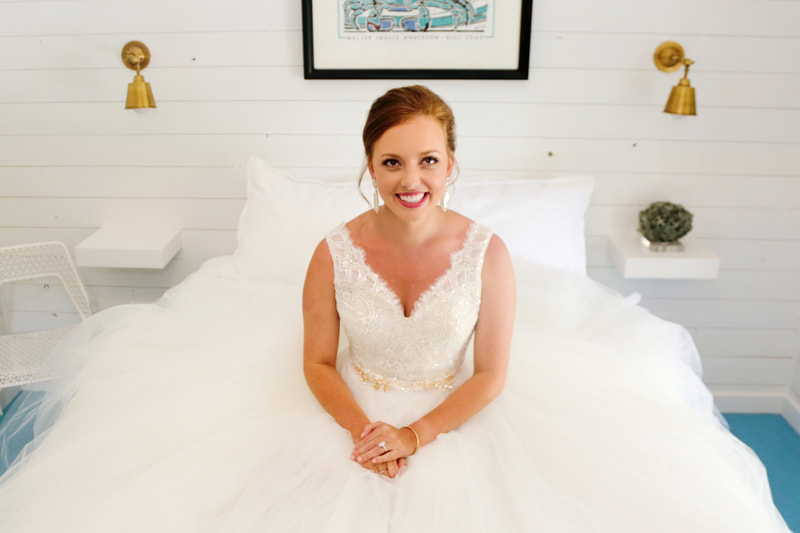 Bride seated in her ballgown in a bright white room