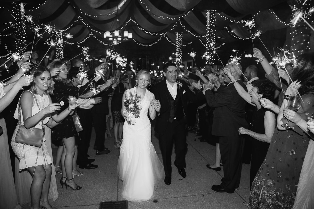 Black and white sparkler exit under string lights