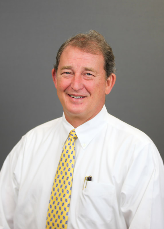 Executive headshot in white shirt and tie on gray backdrop