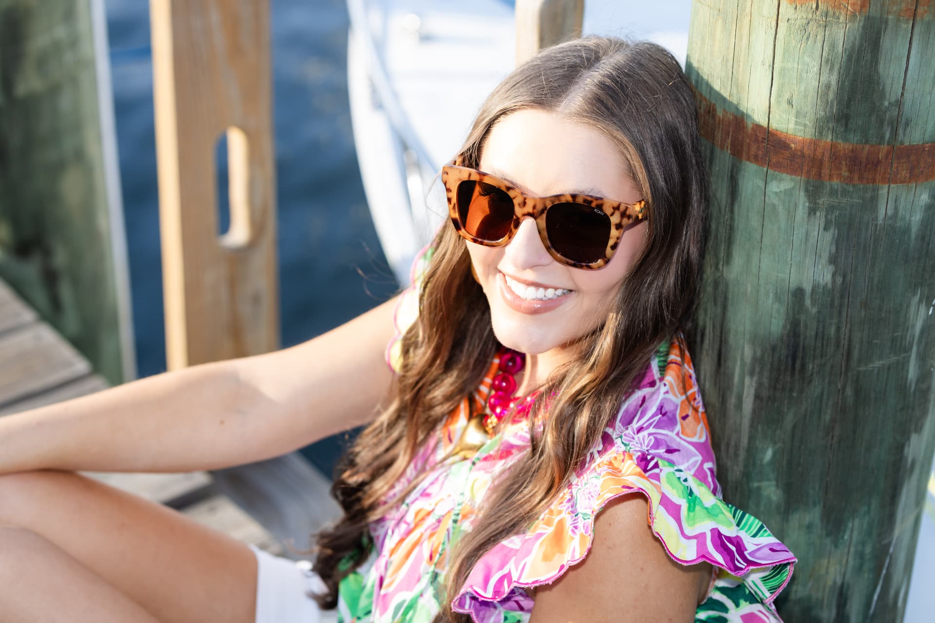 Model in a bright floral resort top on the dock at Fairhope Yacht Club