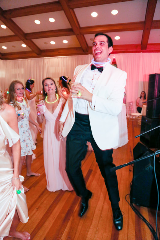 Groom dancing with glow necklaces on the dance floor