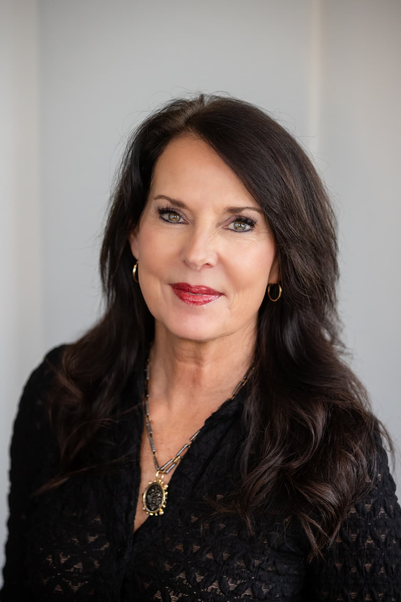 Business owner headshot in black with gold jewelry