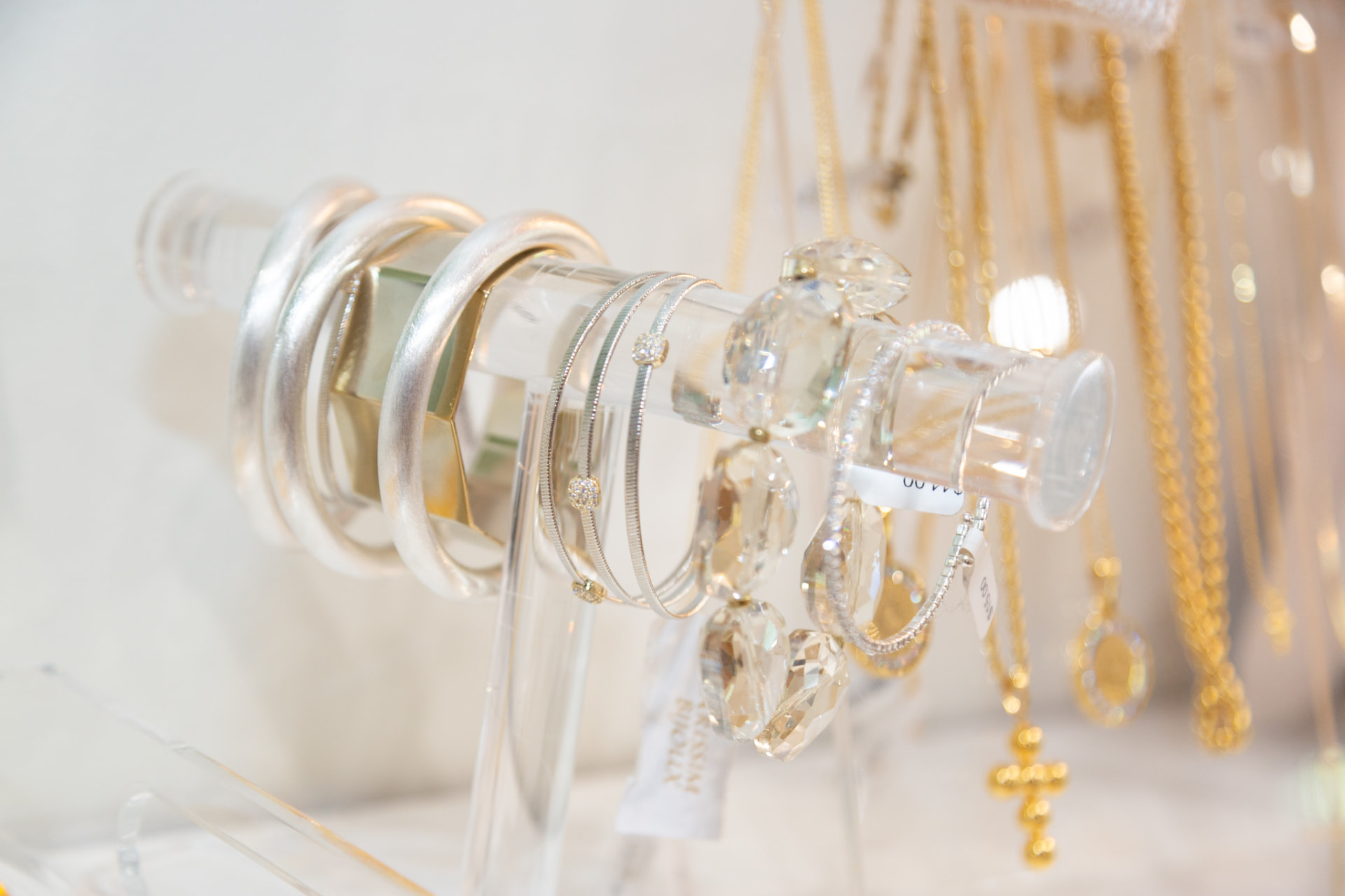 Silver and gold bangles and crystal jewelry on a boutique display
