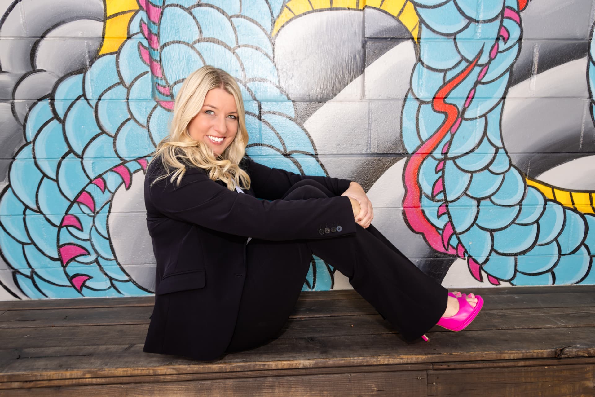 Business owner seated against a mural wall