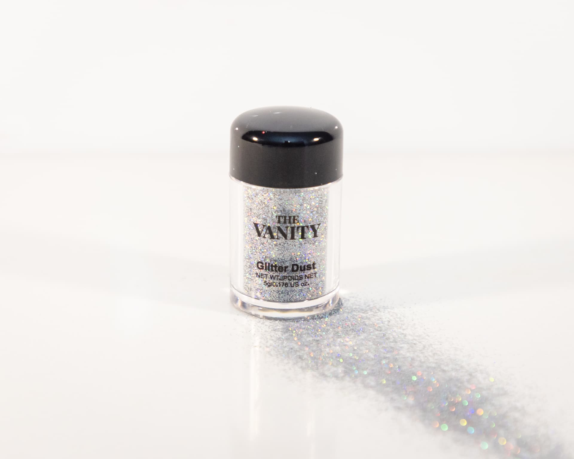 The Vanity Glitter Dust jar in Opal with a glitter trail across white