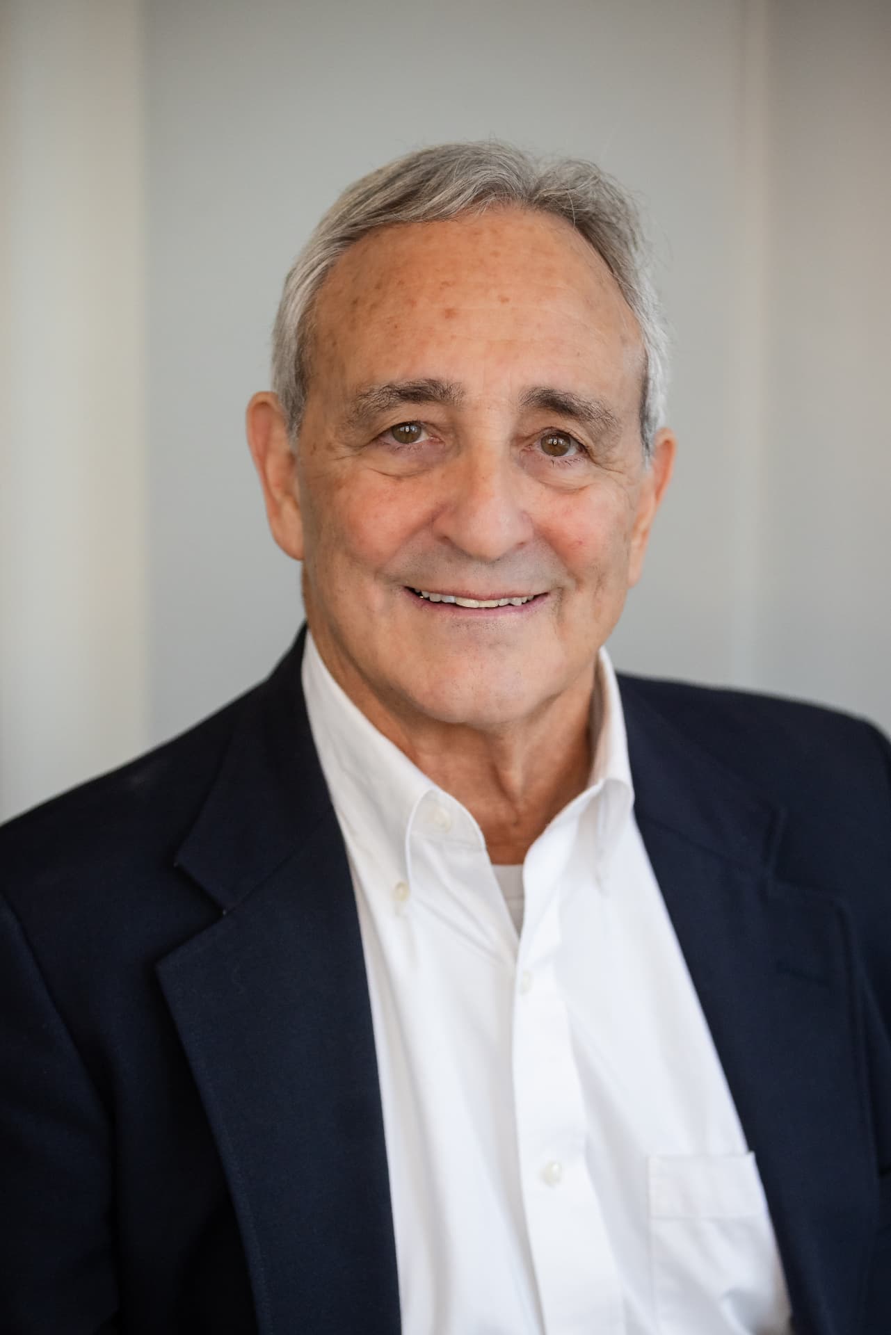 Executive headshot in a navy blazer and white shirt