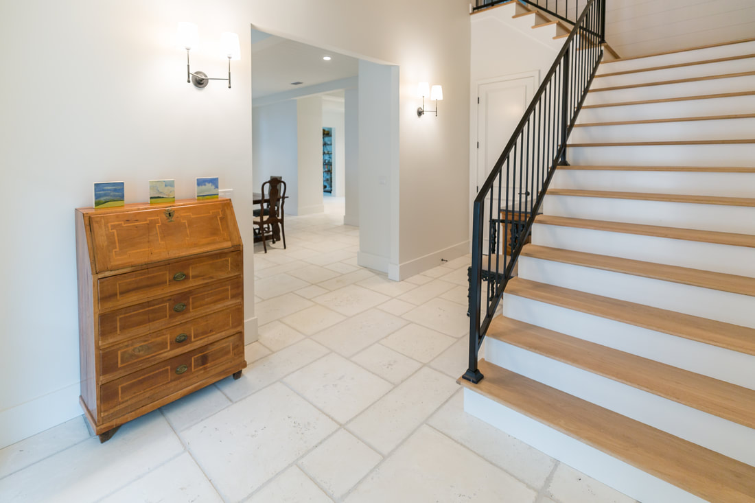 Entry hall with limestone floors, antique secretary and oak staircase