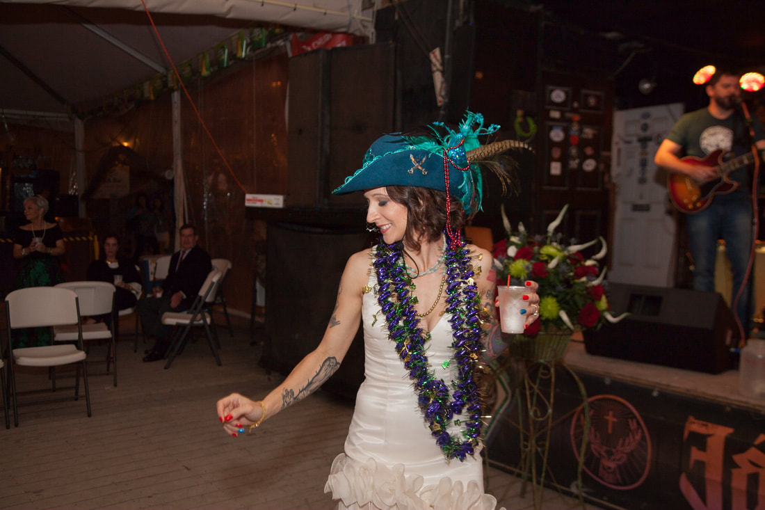 Bride dancing in a feathered hat with a live band