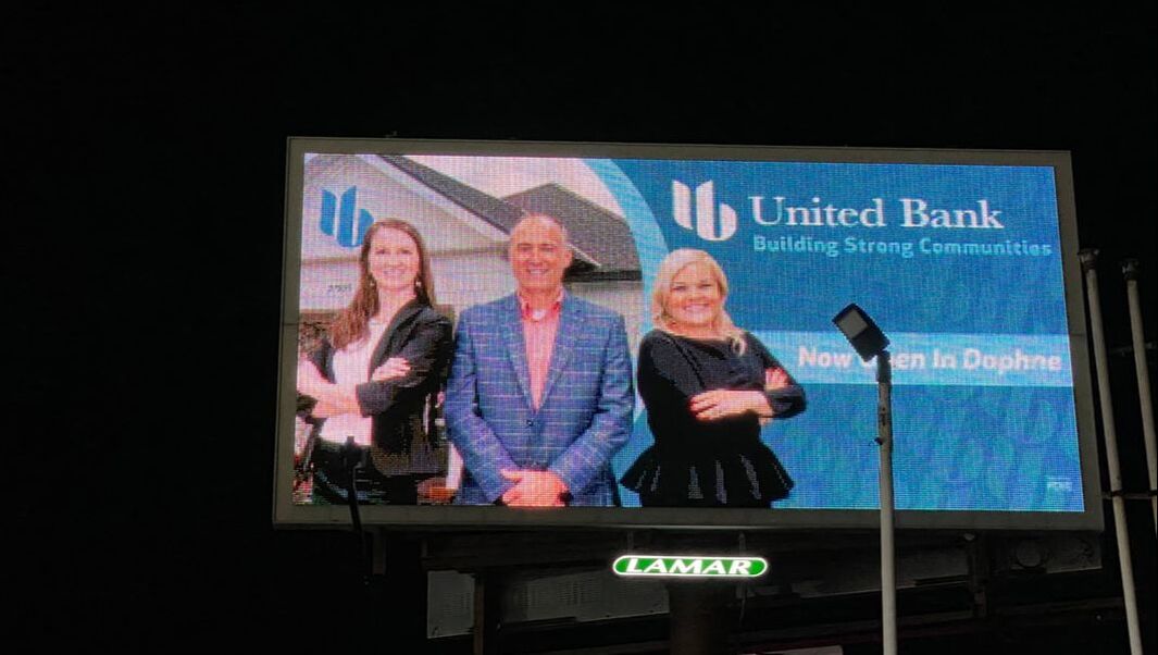 The same United Bank team headshot displayed on a Lamar billboard at night